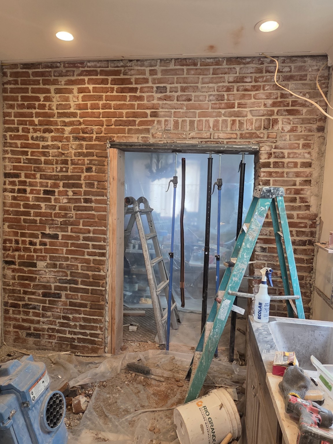 Load-bearing brick wall opening with temporary structural support